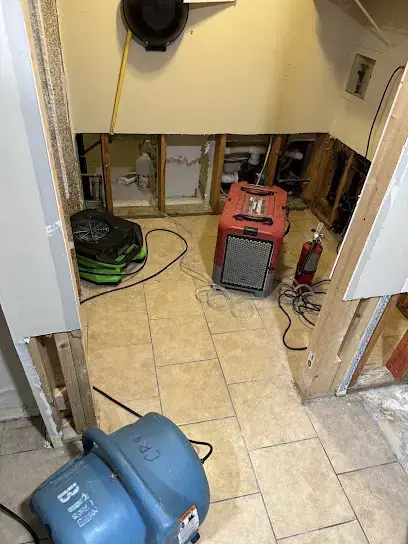 Drywall cut away at the base of the walls with air movers and a dehumidifier running on tile